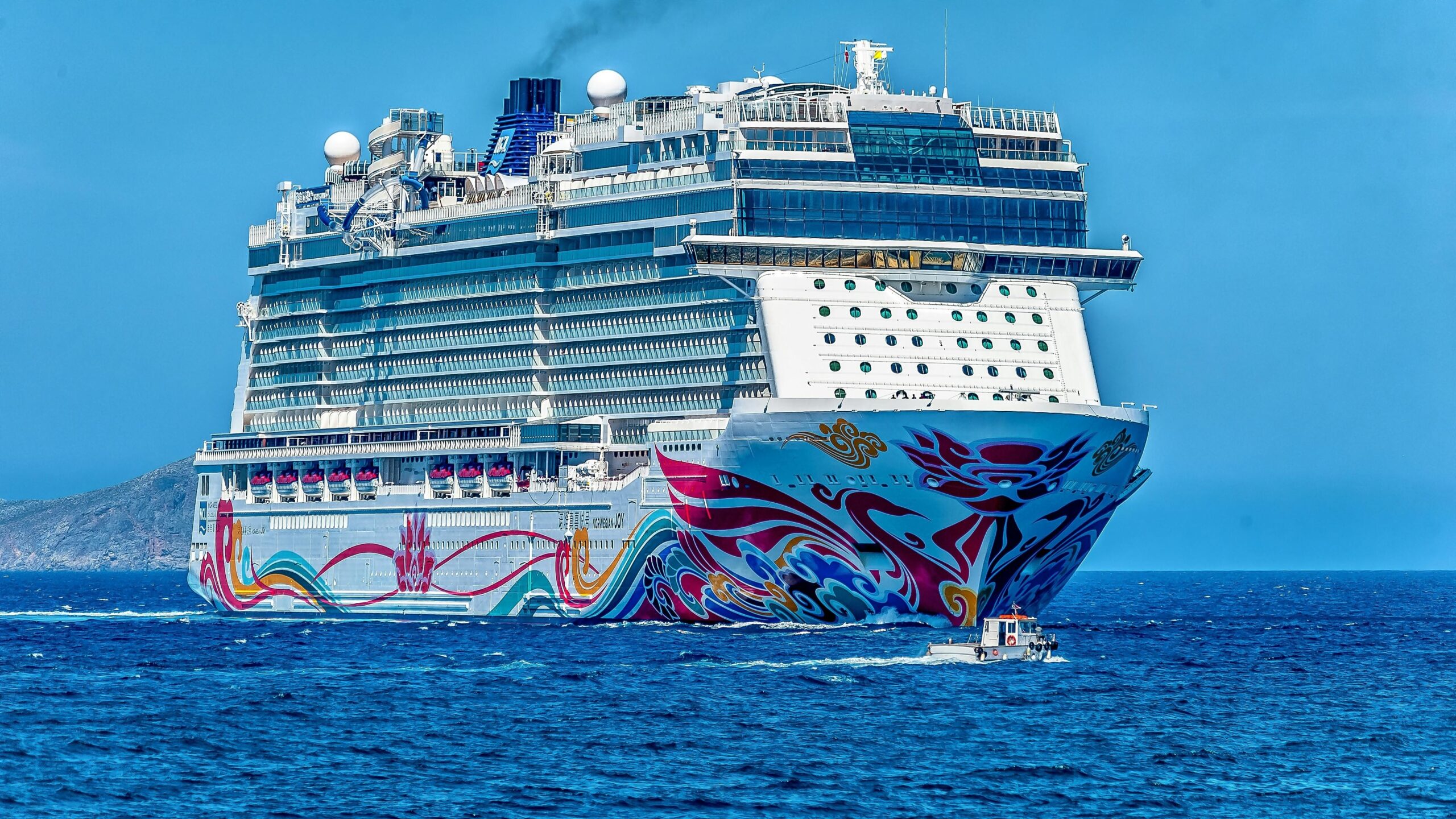 Cruise Ship sailing on the open sea,Aerial view of a Cruise Ship,Passengers relaxing on the deck of a Cruise Ship,Luxurious interior of a Cruise Ship cabin,Cruise Ship docked at a tropical port,Sunset behind a Cruise Ship on the ocean